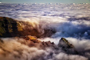 Bulutların üzerinde gün doğumu olan doğa arka planı. Portekiz 'in Madeira adasındaki Pico do Arieiro dağının tepesinde yer alır. Dağlar sislerin ve bulutların arasında gizlidir..