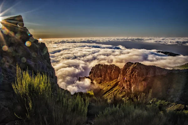 Natuur achtergrond met zonsopgang boven wolken. Het ligt op de top van de berg Pico do Arieiro, Madeira, Portugal. De rijzende zon heeft een gouden kleur. — Stockfoto