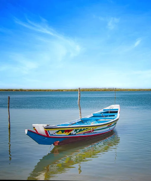 Tradycyjne kolorowe drewniane łodzie na rzece w morskiej lagunie i piękne niebo w tle, Afryka, Senegal. — Zdjęcie stockowe