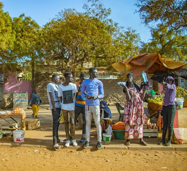MBour, Senegal, ÁFRICA - 22 de abril de 2019: Um grupo de pessoas está à margem do mercado de frutas, onde os moradores oferecem frutas tropicais como melões, manga, laranjas, limões — Fotografia de Stock