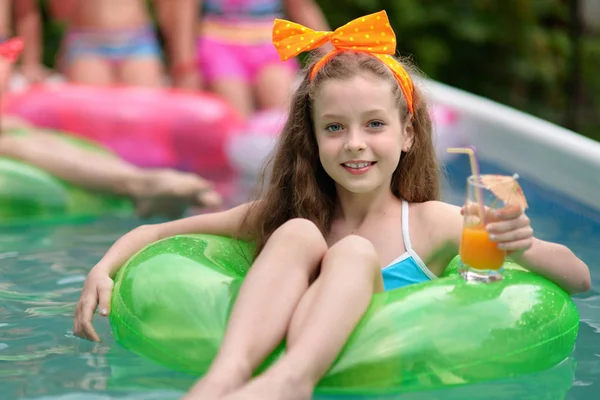 Porträtt av liten flicka i tropisk stil i en pool — Stockfoto