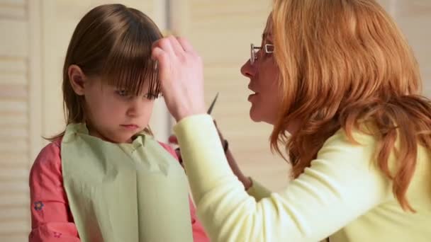 Мать подстригла волосы грустной девочки — стоковое видео