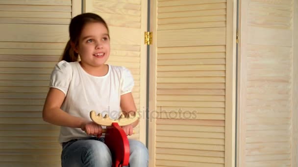 Niña en caballo de madera — Vídeos de Stock