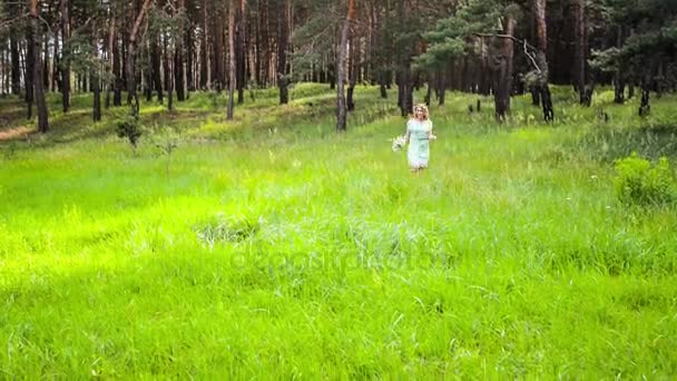 Blonde Frau mit Blumen im Wald — Stockvideo