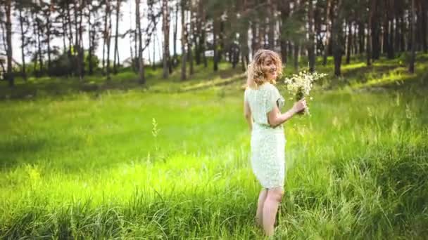 Blonde woman with flowers in forest — Stock Video