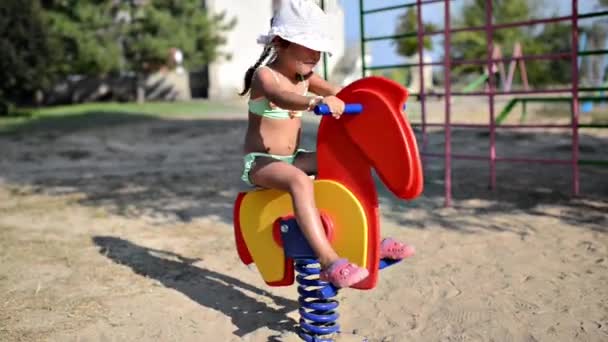 Маленька дівчинка в ігровому дворі — стокове відео