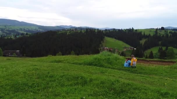 Meisjes in regenjassen op weide — Stockvideo