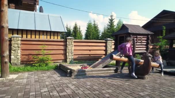 Meisjes swingen op buitenshuis werf — Stockvideo