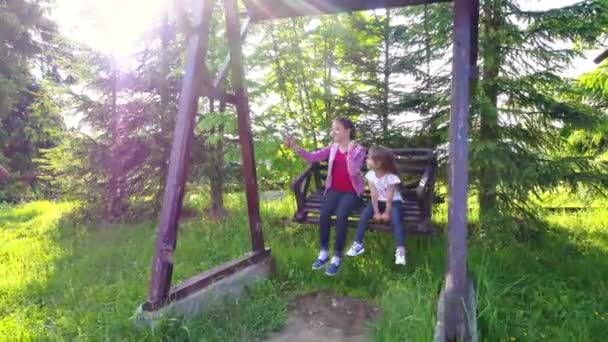 Meninas balançando no pátio ao ar livre — Vídeo de Stock