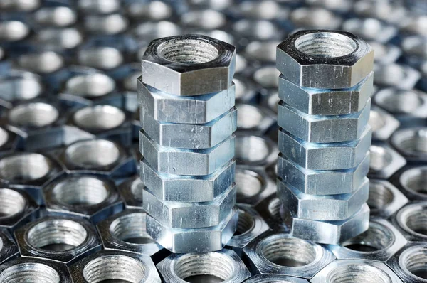 Close-up of a stack of chrome metal nuts — Stock Photo, Image