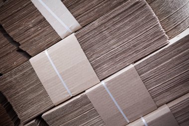 Üst tarafta büyük karton yığınları var.