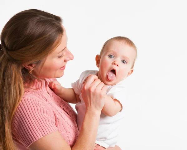 Positive young mother holds on her hands — Stock Photo, Image