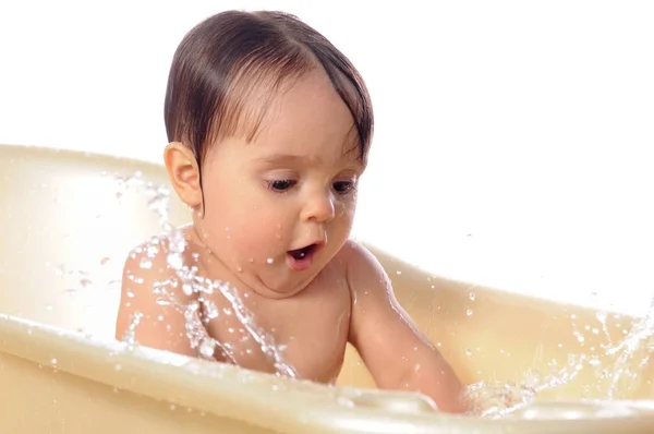 Niña feliz bajo salpicaduras de agua en el baño — Foto de Stock