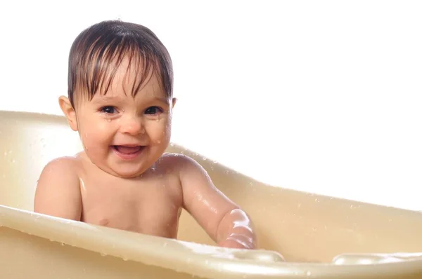 Happy baby girl under splashes of water in bath — Stock Photo, Image