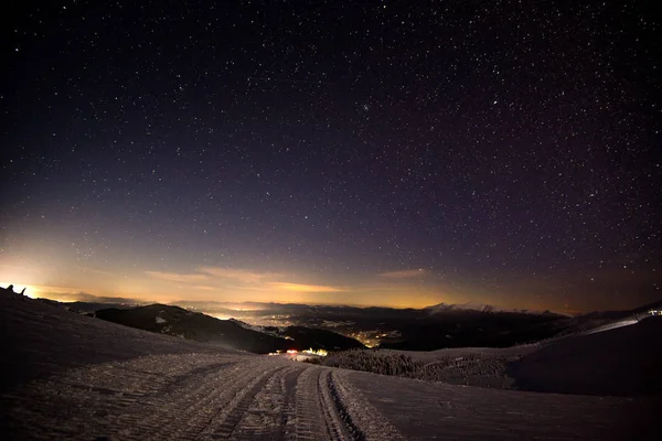 Widok nocny ośrodka narciarskiego ze wzgórzami — Zdjęcie stockowe