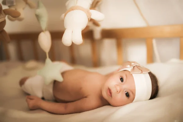 Yeni doğmuş bebek beşikte oyuncakların arasında yatıyor — Stok fotoğraf