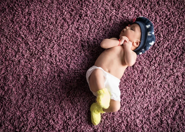 Petit nouveau-né avec un chapeau sur la tête dort doucement — Photo