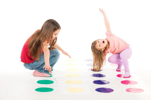 Två lyckliga flickor spelar Twister spel — Stockfoto