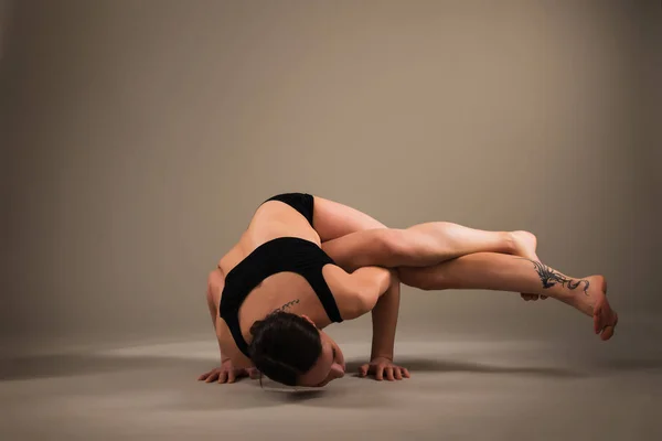 Slanke atletische jonge vrouw doet een handstand — Stockfoto