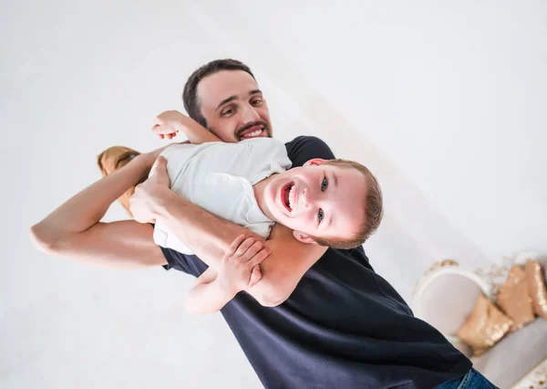 Feliz padre juega con poco travieso hijo — Foto de Stock