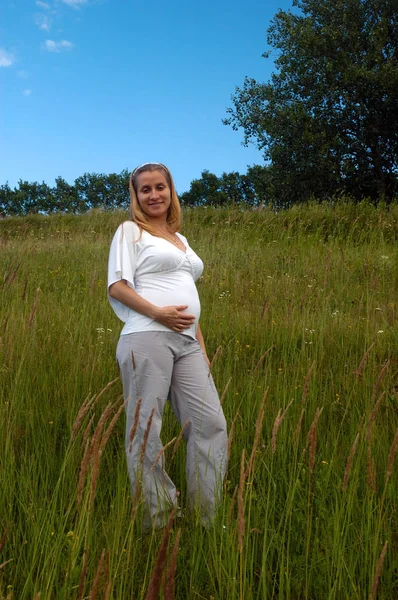 Hermosa mujer embarazada relajándose afuera en el parque — Foto de Stock
