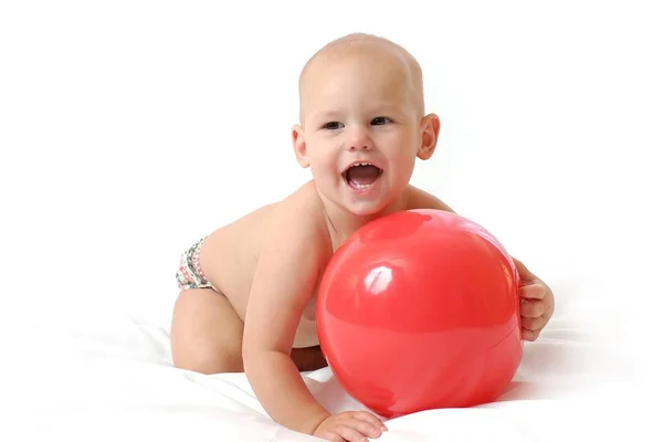 Klein mollig baby bleke de rode speelgoed bal — Stockfoto