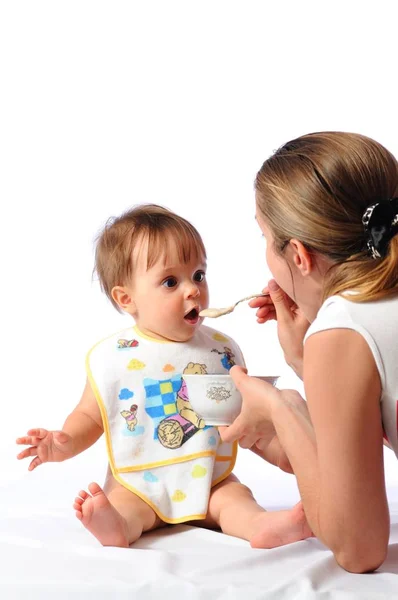 Мати годує здивовану дитину з ложки — стокове фото