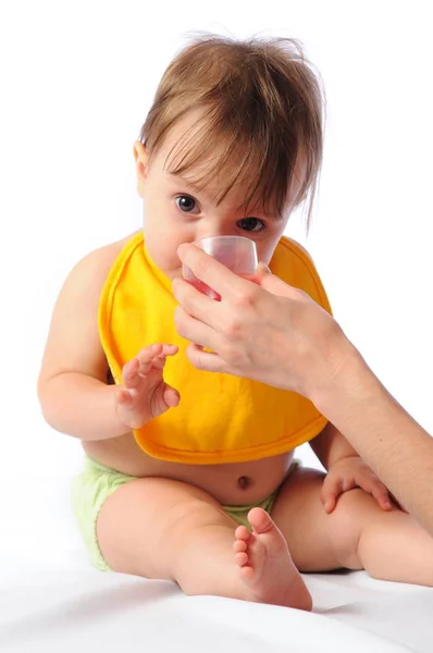 Маленька дитина п'є воду з чашки — стокове фото