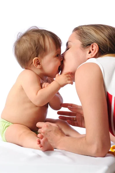 Mãe beija pequena menina — Fotografia de Stock