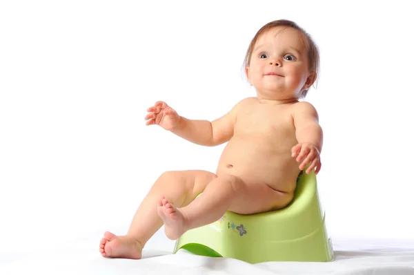 Funny baby sitting on green potty — Stock Photo, Image