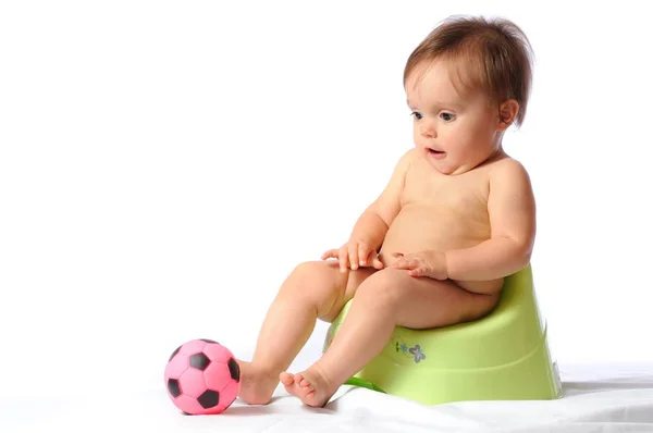 Funny baby sitting on green potty — Stock Photo, Image