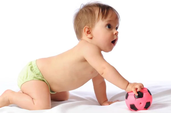 Pequeño bebé juega con una pequeña pelota de fútbol — Foto de Stock