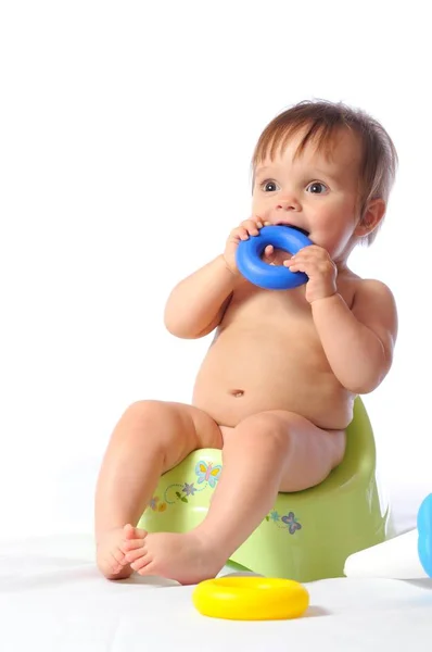 Baby zit op het potje en speelt speelgoed — Stockfoto