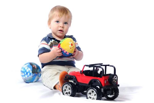 Peuter speelt met geliefde speelgoed holding pluche bal — Stockfoto