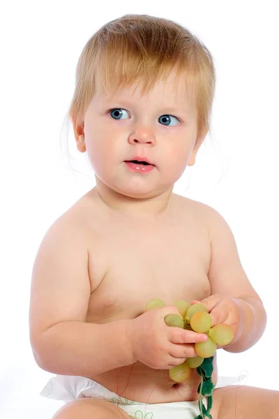 Ragazzo seduto vicino cesto di vimini e in possesso di uva — Foto Stock