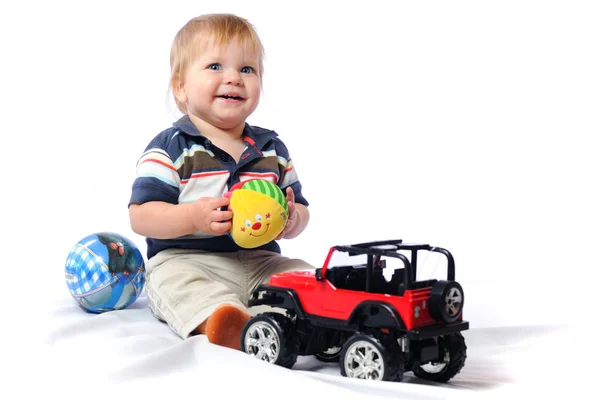 Toddler plays with loved toy holding plush ball — Stock Photo, Image