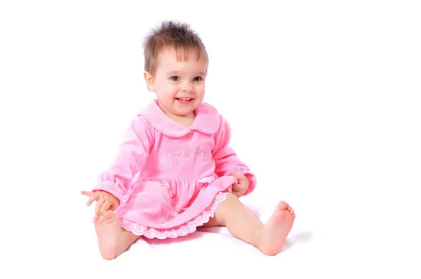 Laughing baby in pink dress holding toes — Stock Photo, Image