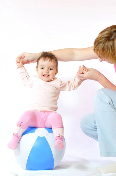 Klein baby meisje zit op opblaasbare bal — Stockfoto