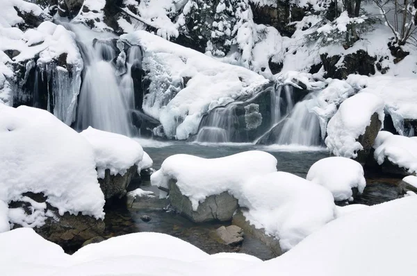 Прекрасный снежный водопад в горах — стоковое фото