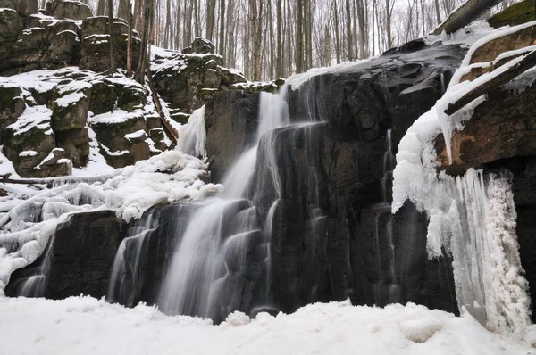 Une petite cascade de montagne couverte de neige — Photo