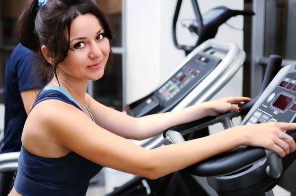 Woman doing exercise on exercise bike at gym — Stock Photo, Image