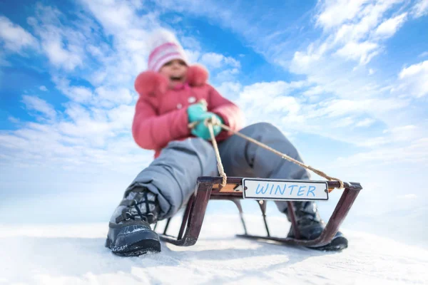 Gelukkig meisje sleeën buiten op heldere winterdag — Stockfoto