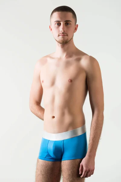 Young man in orange mens underpants standing and looking at camera — Stock Photo, Image