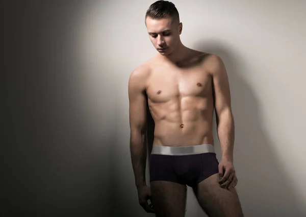 Young man model in brown underpants standing and showing his body — Stock Photo, Image