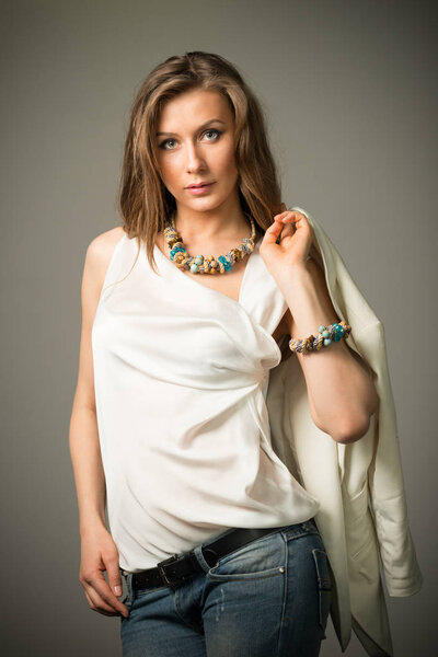 Beautiful young brunette woman in stylish casual clothing with unusual accessories