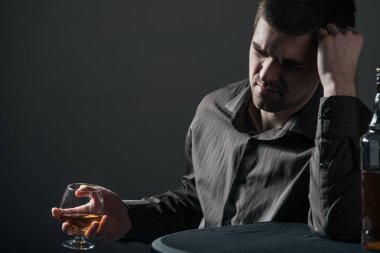Üzgün, duyarsız genç adam içiyor.