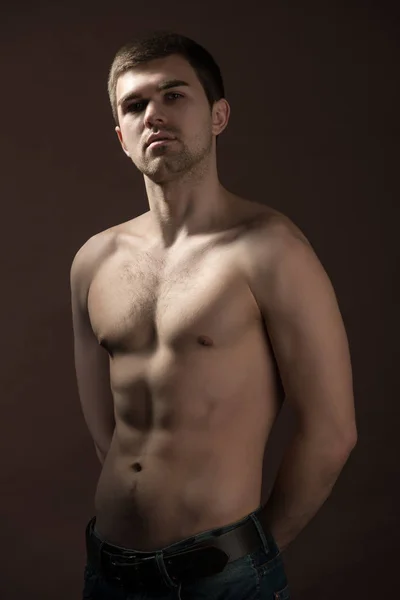 Fiatal férfi modell barna alsónadrágban áll, és mutatja a testét — Stock Fotó