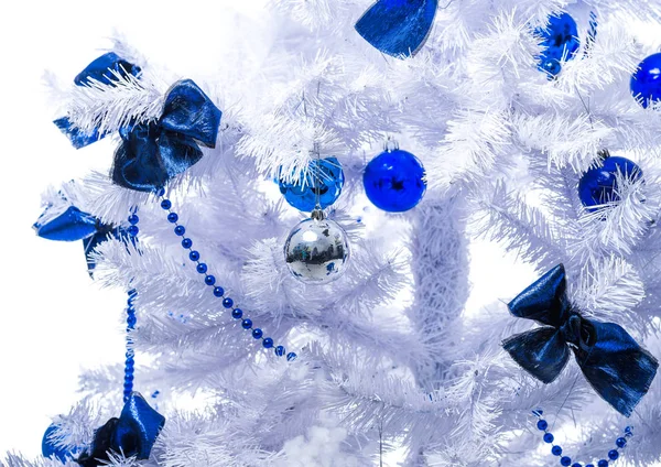 Синие игрушки висят на белой елке — стоковое фото
