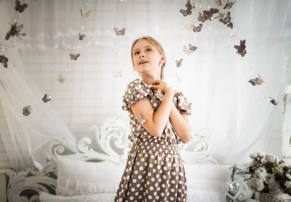 Bewitched little girl in a blue polka-dot dress