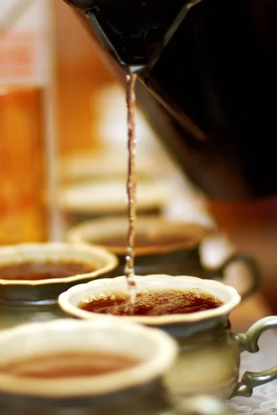 Várias xícaras de chá quente, processo de preenchimento — Fotografia de Stock